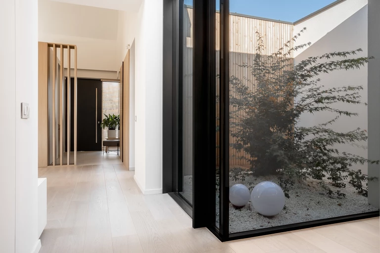 Światło w roli głównej. Minimalistyczny Atrium House projektu MOKAA