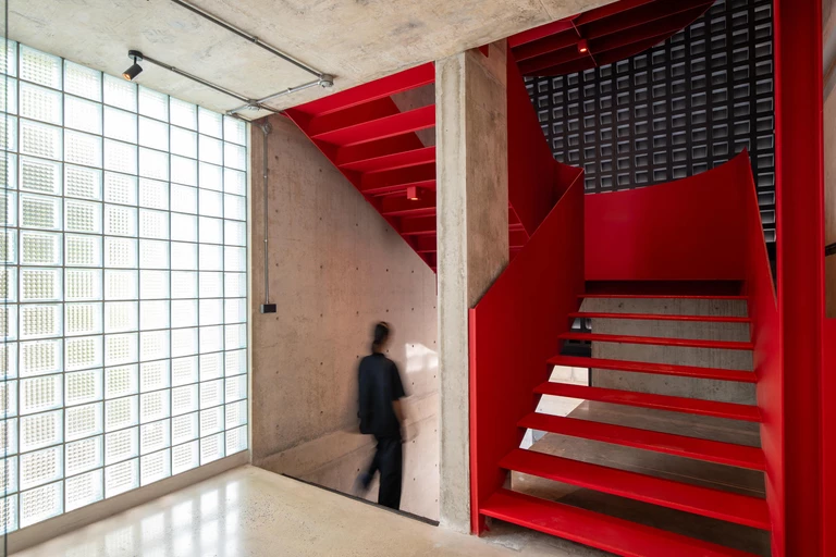 Beton i czerwień, praca i oddech. Hybrydowa rezydencja autorstwa Studio Krubka