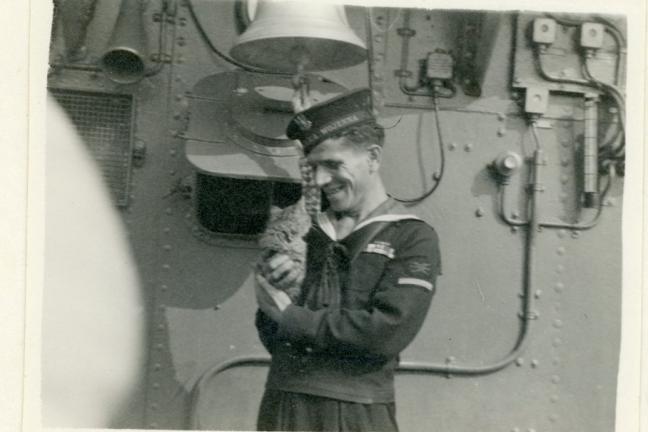 Zdjęcie czarno-białe marynarza z kotem na statku